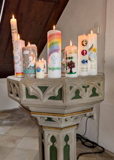 Die Taufkerzen auf dem Taufstein